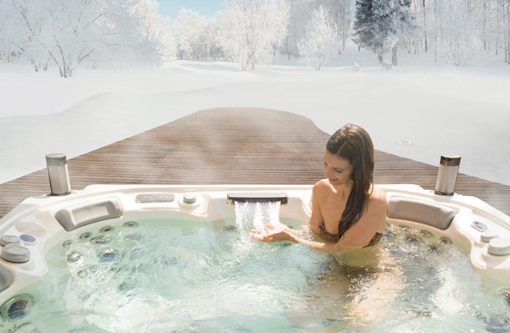 If it snows on your Wellis Spa, take a soak in it. This woman is enjoying a leisurely soak in her spa after a snow that covers trees in the background.