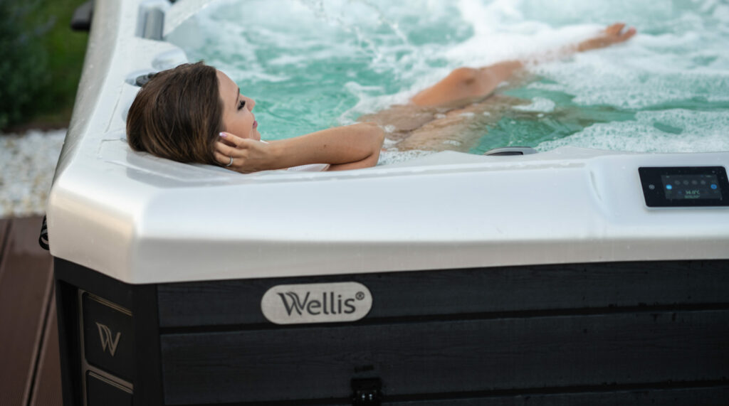 A woman relaxes and listens to an audio book in her Wellis Hot Tub. The MyMusic system allows you to listen while you soak in your hot tub.
