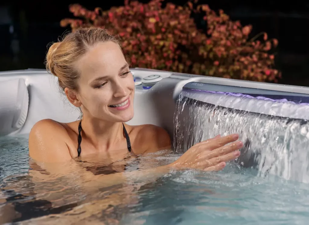 Picture of a person sitting in one of Wellis' 3-person hot tubs.