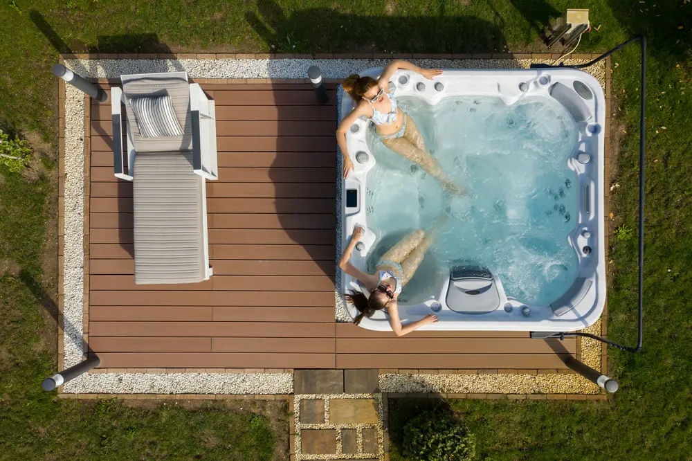 Picture of two women lounging in a 7-person hot tub from Wellis.