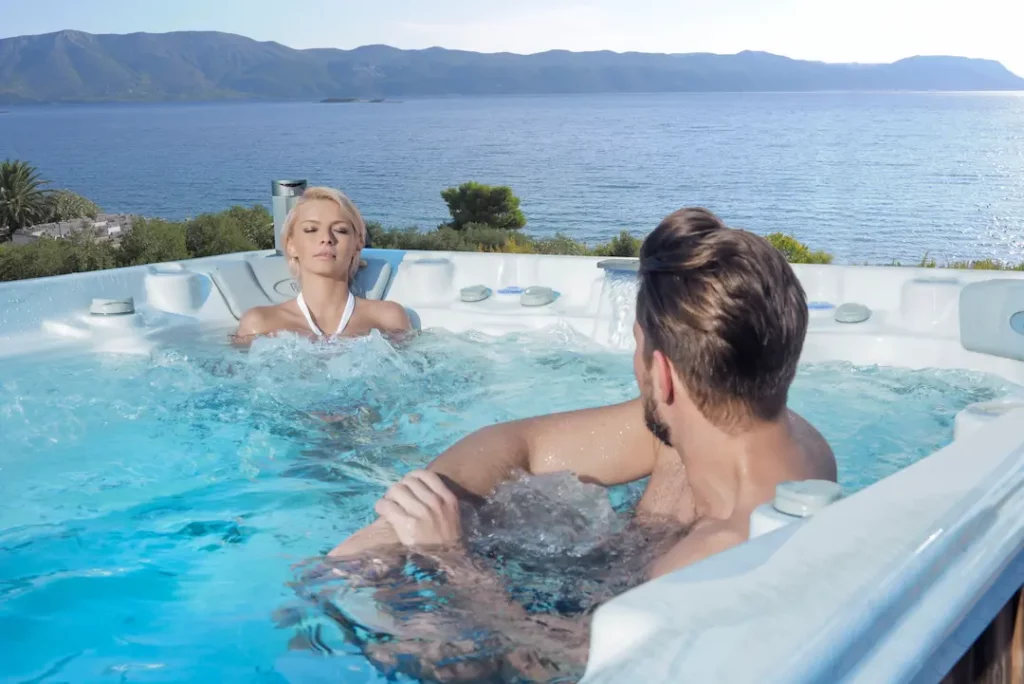 Picture of two people lounging in the best large hot tubs by Wellis Spa.