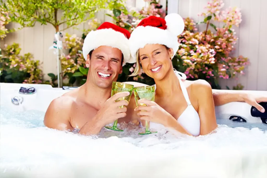 Picture of a couple sipping holiday cocktails in a hot tub.