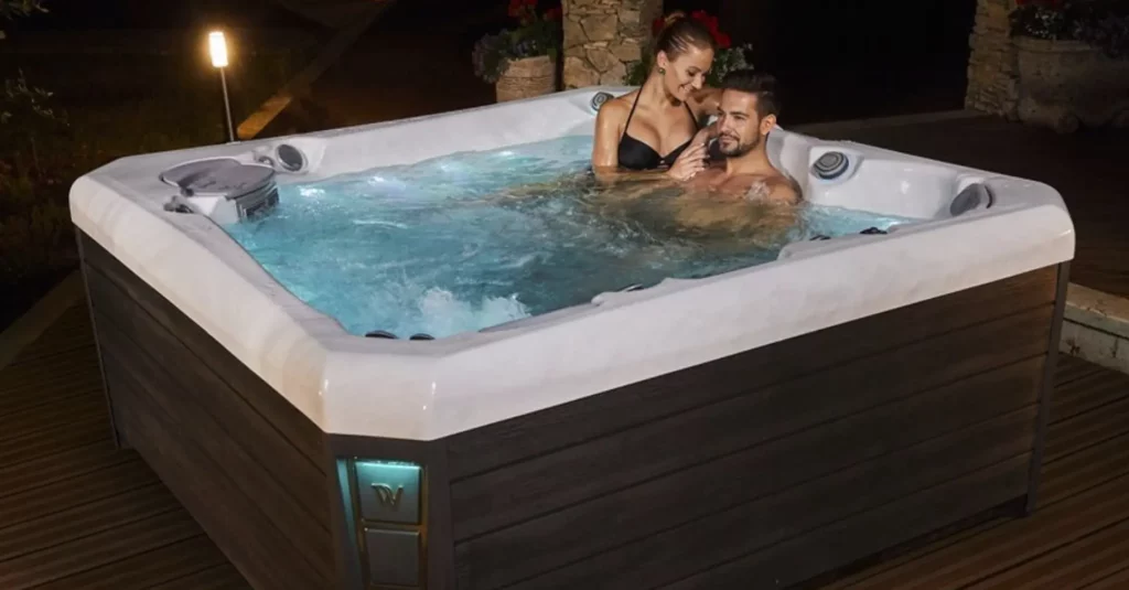 Picture of a couple in a hot tub on a deck.