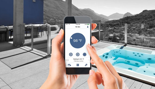 Picture of a person holding a mobile device next to their spa for the blog about hot tub with a smartphone app.