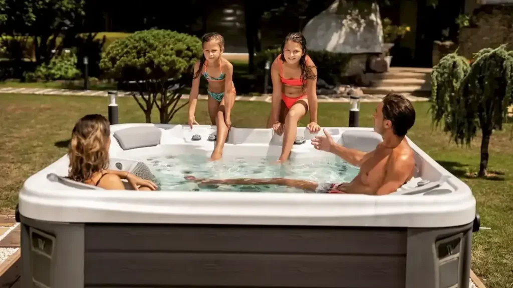 Picture of a family getting into a spa for the blog about how long do hot tubs last.