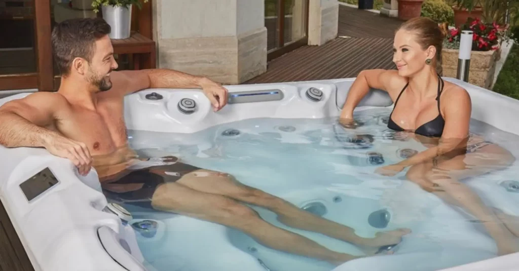 Picture of two people in a hot tub for the article about how much does a hot tub weigh?
