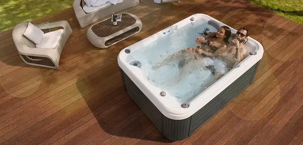 Picture of people relaxing in a lounger hot tub. 