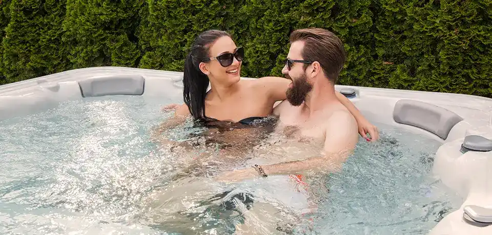 A couple sitting in the smallest hot tub for sale