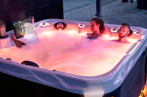 man and woman in hot tub with spa accessories