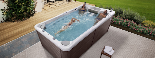 man swims and two people sit in a swim spas
