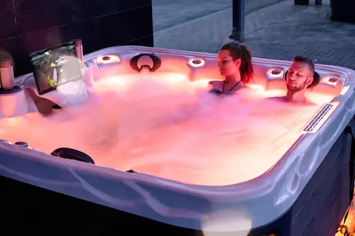 Picture of two people relaxing and enjoying their Wellis hot tub accessories.