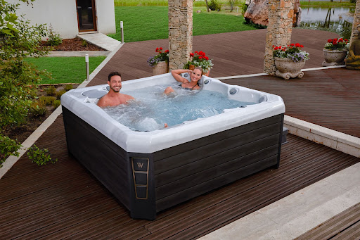 Picture of a couple soaking inside of a Wellis luxury hot tub, one of the best hot tub brands in America.